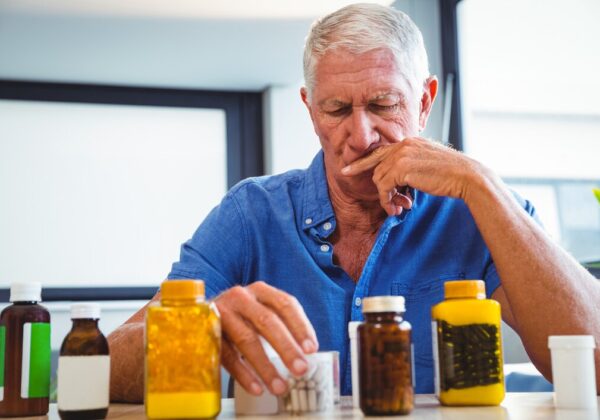 A senior looking thoughtfully at a calendar, pillbox, or asking for help with a routine task