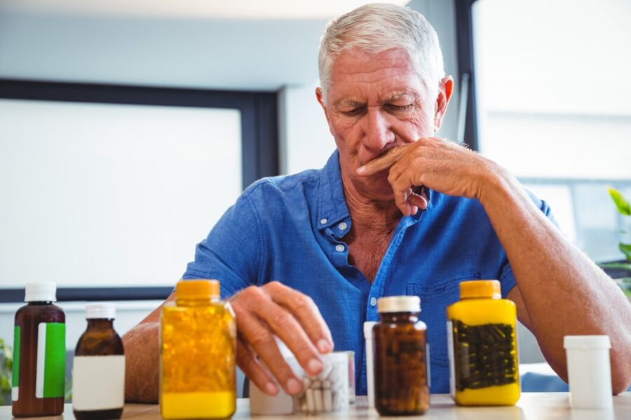 A senior looking thoughtfully at a calendar, pillbox, or asking for help with a routine task
